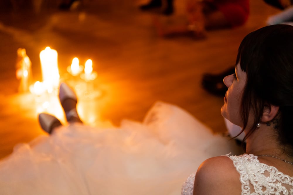 Braut im Kerzenlicht zum Ende der Hochzeitsparty hin